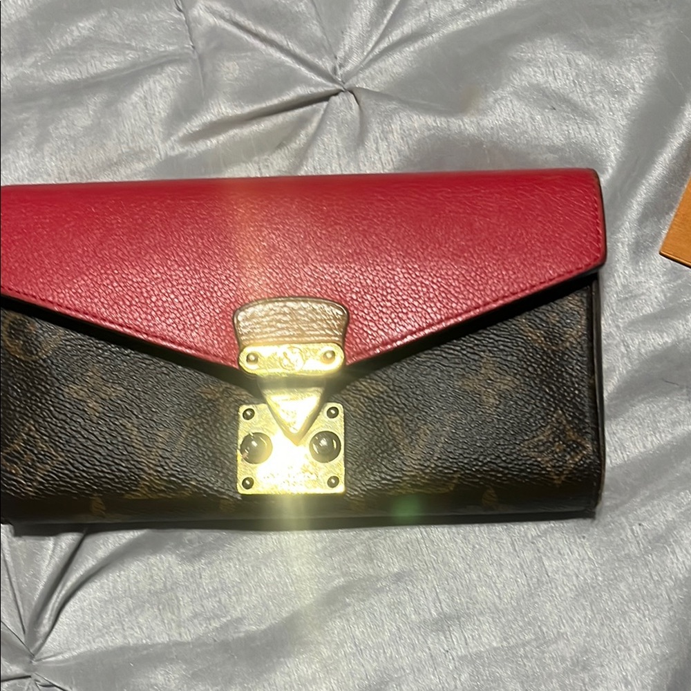 Lv wallet with red top and gold buckle